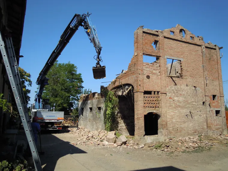 Demolizione controllata di un edificio esistente con mezzi da cantiere