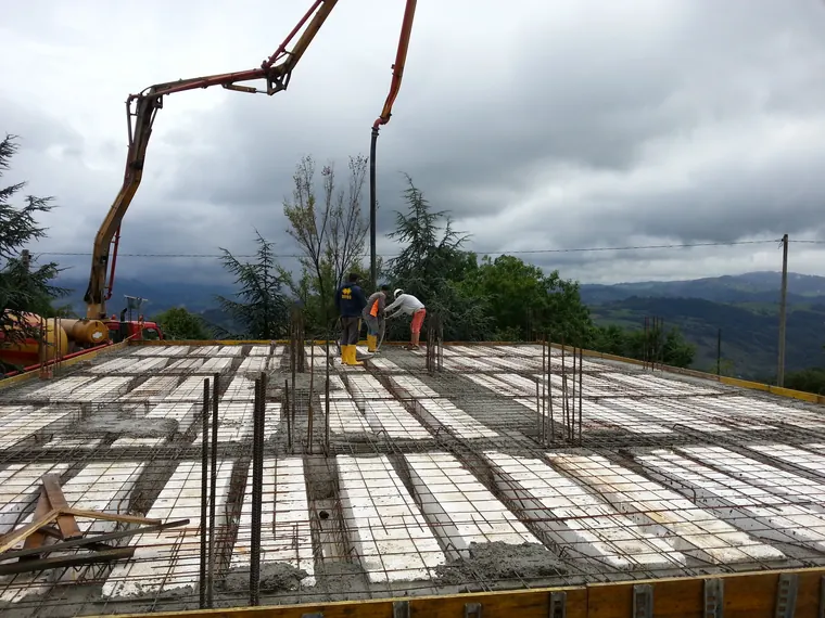 Preparazione di un solaio con armature e pompa per calcestruzzo